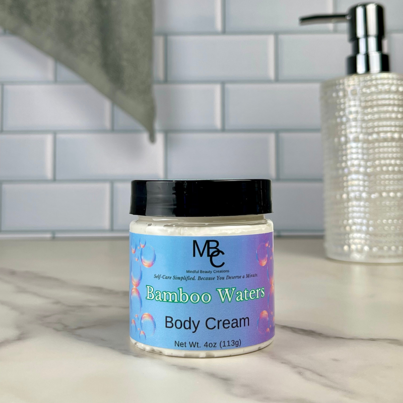 Jar of Bamboo Waters Body Cream on a bathroom counter with soap dispenser in the background.