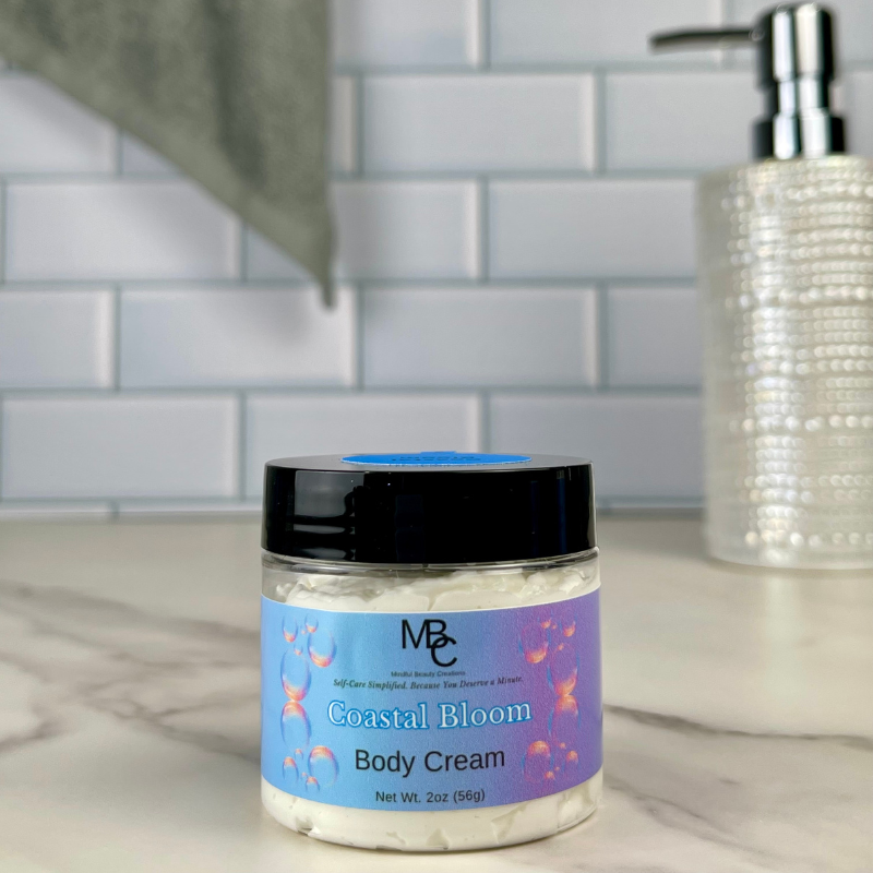 Coastal Bloom Body Cream jar on a bathroom counter with a tiled wall background