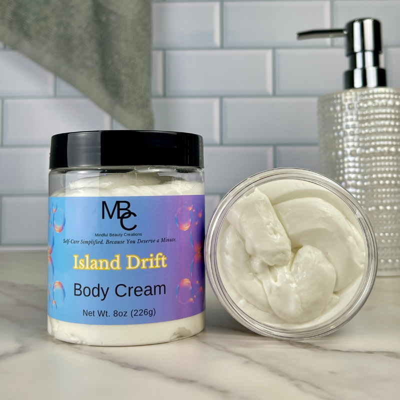 Jar of Island Drift Body Cream with a pump dispenser in the background