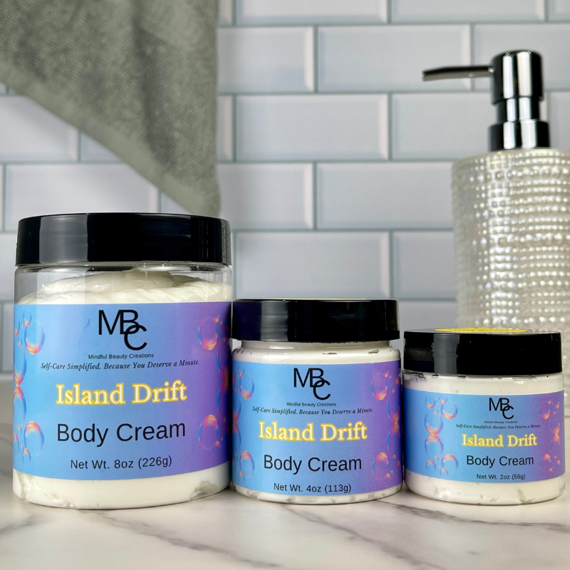 Three jars of Island Drift body cream on a bathroom counter with a tiled wall background.