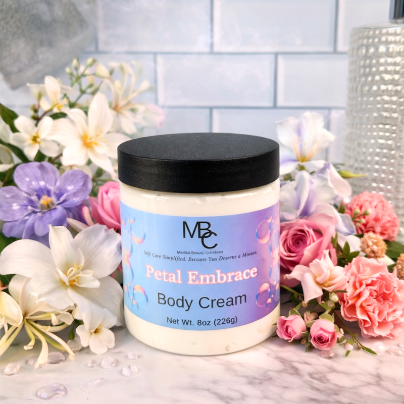 Body cream jar labeled 'Petal Embrace' surrounded by flowers on a marble surface.