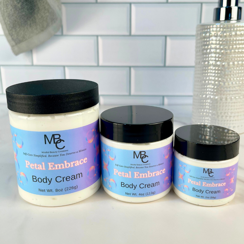 Three jars of 'Petal Embrace' body cream with black lids on a bathroom counter.