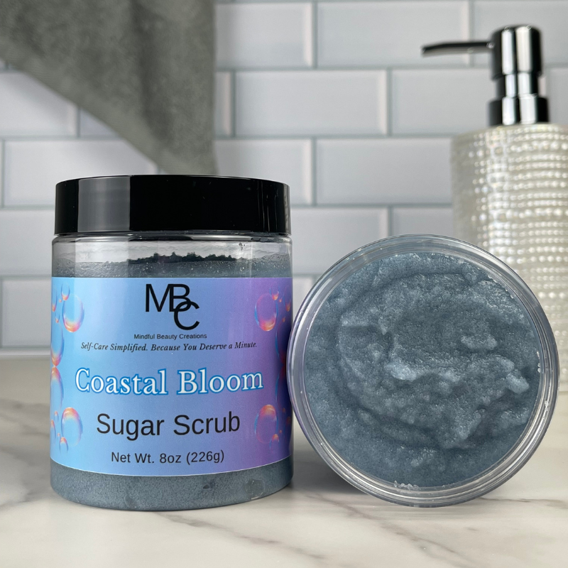 Coastal Bloom Sugar Scrub jar with open lid on a bathroom counter
