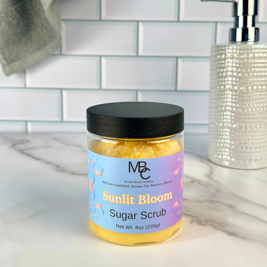 Jar of Sunlit Bloom Sugar Scrub on a bathroom counter with a tiled wall background