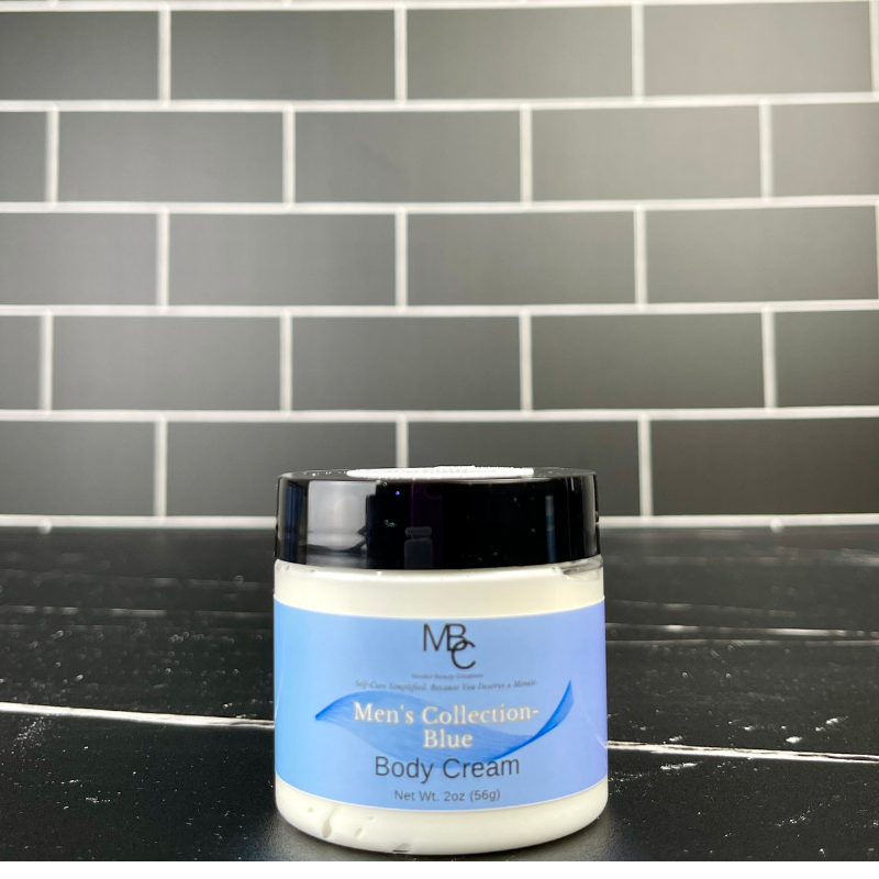 Jar of Men's Collection Blue Body Cream on a black surface with a gray tiled wall background